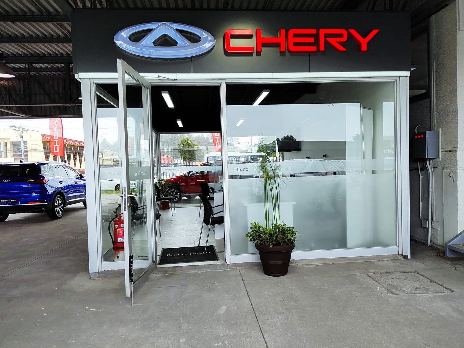 Acceso de showroom automotriz con macetero de exterior en la entrada